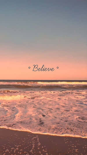 粉紅色和藍色的夕陽映照在海浪上，中央有「Believe」字樣。 — 美學 壁紙