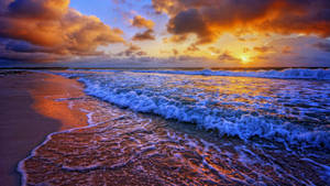 夕陽下的海洋，海浪拍打沙灘。 — 海灘日落 壁紙