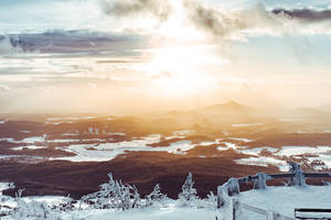 夕陽下的雪山景觀，金色光芒和霜凍的樹木 — 冬季風景 壁紙