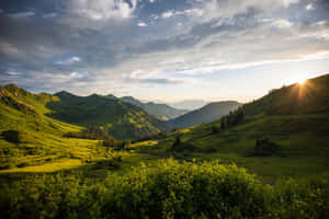 夕陽照耀翠綠山谷，金色光芒與戲劇性雲彩。 — 風景 壁紙