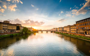 夕陽映照河流，河上有石橋，兩岸有歷史建築。 — 義大利 GIF 壁紙