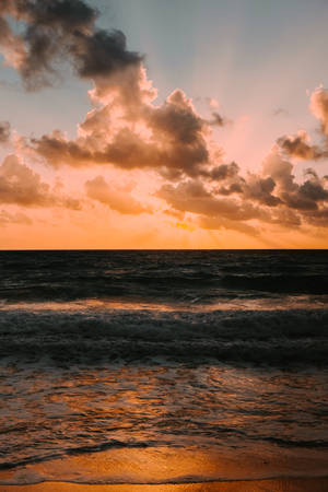海洋上的日落，雲層和波浪在濕沙上反射出橙色光芒 — 日落 壁紙