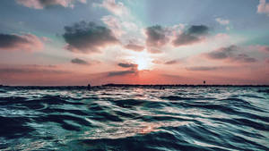 夕陽下的海洋，有雲和遠處陸地 — 早晨榮耀 壁紙