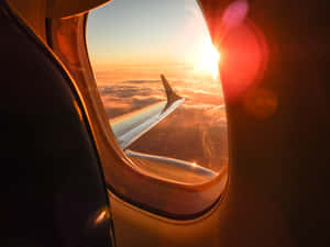 從飛機窗戶看到的夕陽，帶有機翼和下方的雲層。 — 美學 壁紙