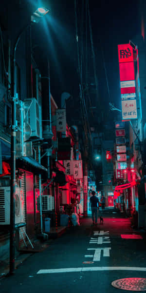 夜晚，一個人獨自走過充滿活力的霓虹燈城市小巷。 — 極簡 iPhone 壁紙