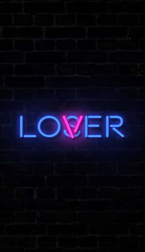 霓虹燈牌在深色磚牆上以藍色和粉紅色顯示「LOSER」。 — 省電 壁紙