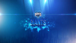 藍色「GIANTS」運動標誌被體育場燈光照亮，位於夜晚的城市天際線上方。 — 藍色煙霧 壁紙