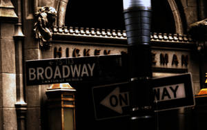 夜晚的 Broadway 街道標誌，石頭建築上有單向箭頭。 — 紐約市夜景 壁紙