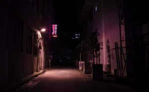 夜晚一條燈光昏暗的小巷，帶有發光的粉紅色霓虹燈汽車旅館招牌。 — 街頭 壁紙