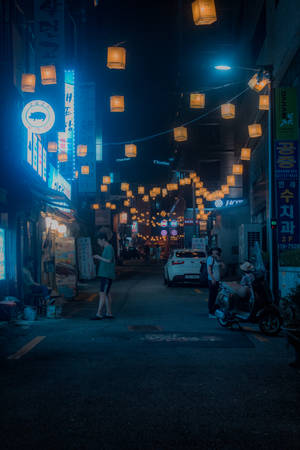 韓國城市小巷中，有發光燈籠和霓虹招牌的夜晚街景。 — 城市燈光 壁紙
