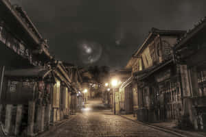 夜晚一條寧靜的日本街道，有傳統木建築和溫暖的路燈。 — 東京喰種風格 壁紙
