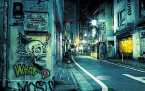 夜晚小巷，有骷髏塗鴉壁畫和發光的霓虹燈招牌。 — 鄰里 壁紙