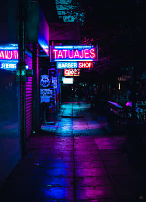 霓虹招牌在夜晚潮濕的城市人行道上發出粉紅色和藍色的光芒。 — OnePlus Pad 2 Pro 壁紙