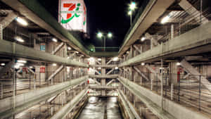 夜晚的多層混凝土停車場，帶有發光標誌和空位。 — 汽車 壁紙