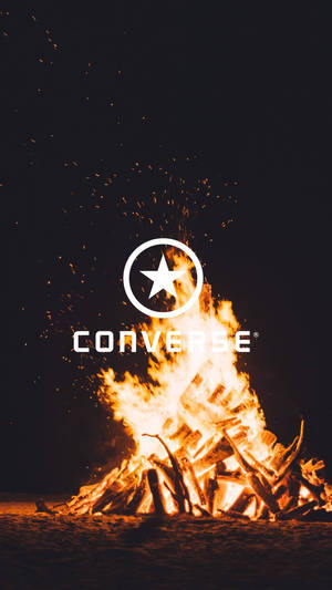 Converse標誌在夜晚燃燒的營火上，火花飛舞。 — Free Fire 標誌 壁紙