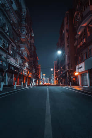夜晚空無一人的城市街道，有發光的街燈和高樓大廈。 — Huawei MatePad Edge 壁紙