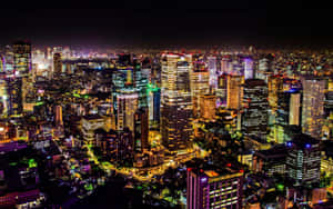 密集市區的夜間鳥瞰圖，摩天大樓和街道燈火通明。 — 城市風景 壁紙