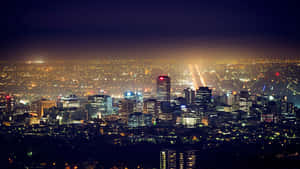 一座燈火通明的城市的全景夜景，擁有高聳的建築物和發光的街道。 — 阿德雷德 壁紙