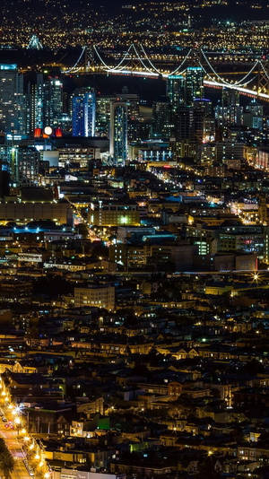 夜晚的城市景觀，燈火通明的建築物和水面上發光的橋樑。