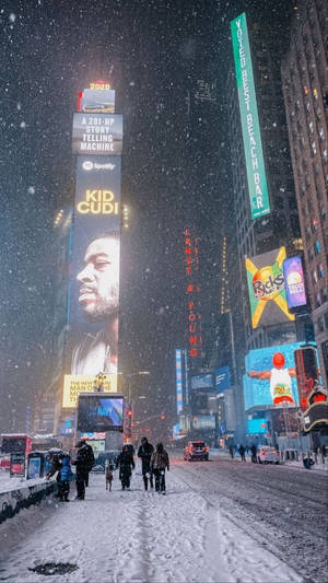 夜晚積雪的時報廣場，閃爍的廣告牌和行走的行人。 — 紐約 壁紙