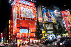 夜晚的東京街道，有發光的動漫廣告牌和行人。 — MacBook Pro M3 壁紙