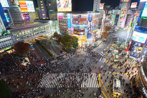 東京擁擠街道十字路口的夜間鳥瞰圖，帶有明亮的霓虹燈招牌。 — 日本 壁紙