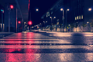 雨夜濕滑的城市街道，閃爍的紅色交通燈反射在濕漉漉的路面上。 — 暮光 壁紙