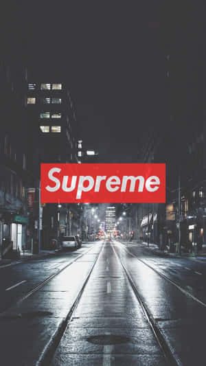 高樓之間夜晚濕漉漉的城市街道上方的紅色Supreme標誌。 — 頂級 iPhone 壁紙