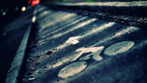 夜晚濕自行車道，背景中有模糊的紅色尾燈。 — 道路 壁紙