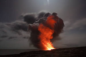 夜晚火山爆發，熔岩和煙霧在星空和海洋的映襯下閃閃發光。 — 火焰動畫 壁紙