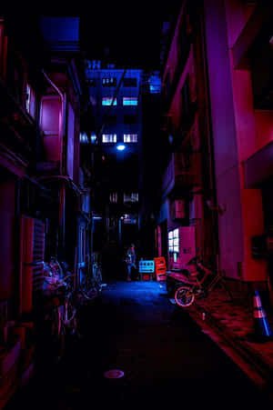 夜晚霓虹燈照亮的小巷，停有機車和腳踏車。 — 賽博龐克城市 壁紙
