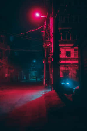 夜晚紅光照亮的小巷，有建築物和架空電線。 — 霓虹紅美學 壁紙