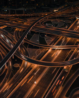 夜間照明複雜的高速公路交匯處，車燈流動。