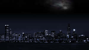 夜晚的城市天際線，燈火通明的建築在星空下，銀河可見。 — 芝加哥 壁紙