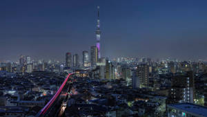 夜晚的東京城市景觀，燈火通明的建築物和發光的晴空塔。 — 城市燈光 壁紙