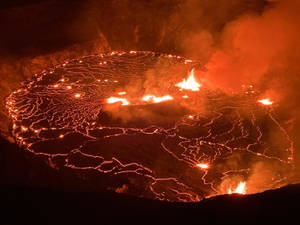 夜晚的火山口，發光的熔岩在表面流動。 — 自然 壁紙