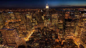 夜晚紐約市天際線的空中景觀，摩天大樓閃閃發光，帝國大廈亮起。 — 東京鐵塔 壁紙