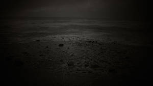 陰暗的海灘，波浪在陰沉的夜空下拍打岩石。 — 憂鬱 GIF 壁紙