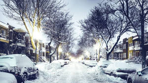 夜晚被雪覆蓋的城市街道，發光的街燈和停放的汽車。 — 城市 壁紙