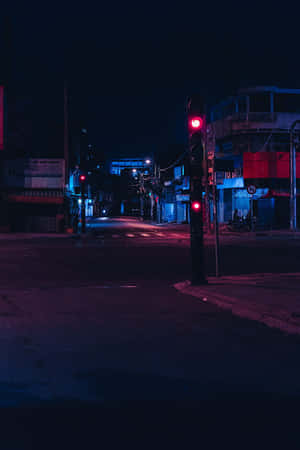 夜晚霓虹燈照亮的街角，帶有發光的紅色交通燈。 — 光線 壁紙