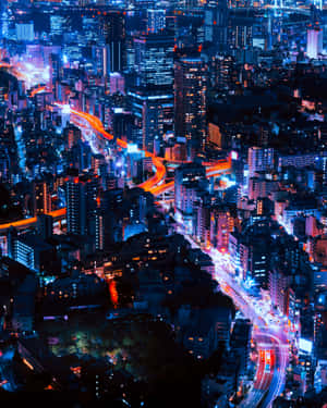 夜晚繁忙城市的鳥瞰圖，霓虹燈閃爍，交通光軌流動。 — 4:5 壁紙