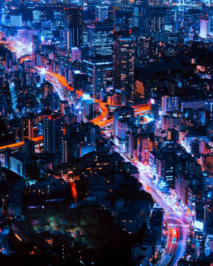 夜晚鳥瞰繁華城市，有發光的霓虹燈和流動的交通。 — 城市風景 壁紙