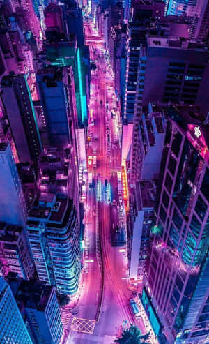 夜晚充滿活力的霓虹燈城市街道鳥瞰圖，周圍是高樓大廈。 — Galaxy Tab A11 壁紙