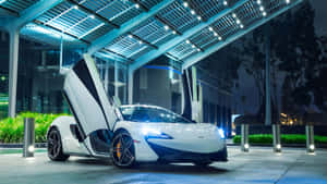 夜間，白色McLaren跑車在藍色照明天篷下打開車門。 — 酷炫F1 壁紙