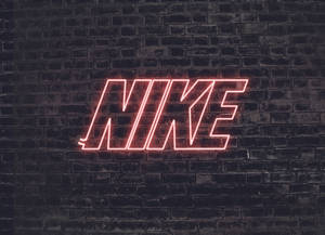 夜間深色磚牆上的紅色霓虹燈Nike標誌
