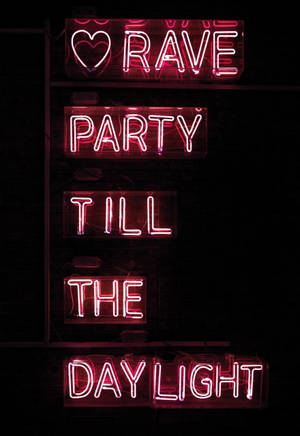 粉紅色霓虹燈牌在深色牆上顯示「Love Rave Party Till The Daylight」。