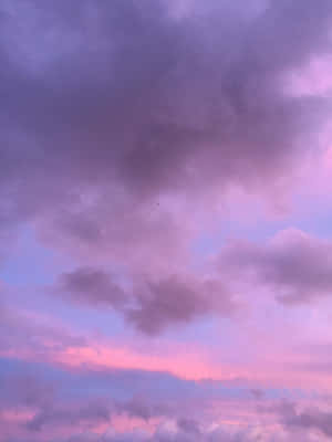 紫色和粉紅色的雲彩在寧靜的暮色天空中飄移。 — 3:4 壁紙