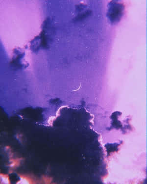 黃昏時分，紫色天空帶有新月和暗雲，閃爍著粉紅色和橙色。 — 淺紫色系美學 壁紙