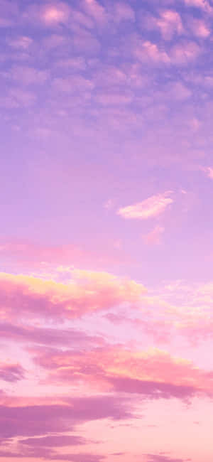 寧靜的天空中柔和的粉紅、紫色和黃色日落雲彩。 — 雲朵 GIF 壁紙