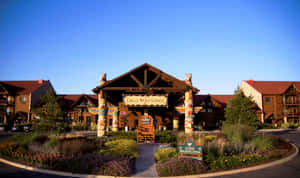 Great Wolf Lodge 入口，木結構建築和色彩繽紛的園景在日落時分。 — 狼 壁紙